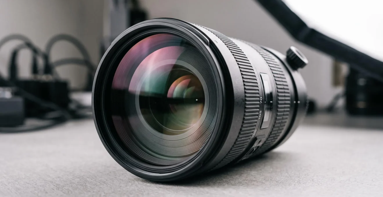 Objectif photographique professionnel montrant les reflets colorés des traitements anti-reflets multicouches sur la lentille frontale